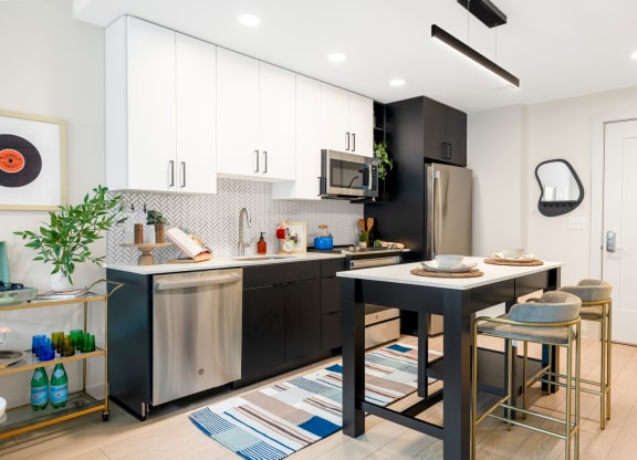 an open kitchen with a large island and a table with three stools