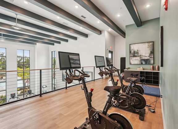 Top level of fitness center with spin bikes and yoga mats at The Crossing