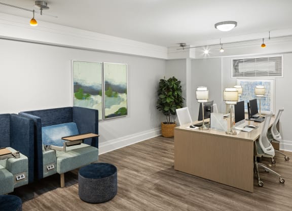 an office with blue chairs and a desk with computers