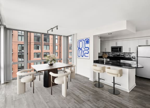 a living room with a kitchen and a table and chairs