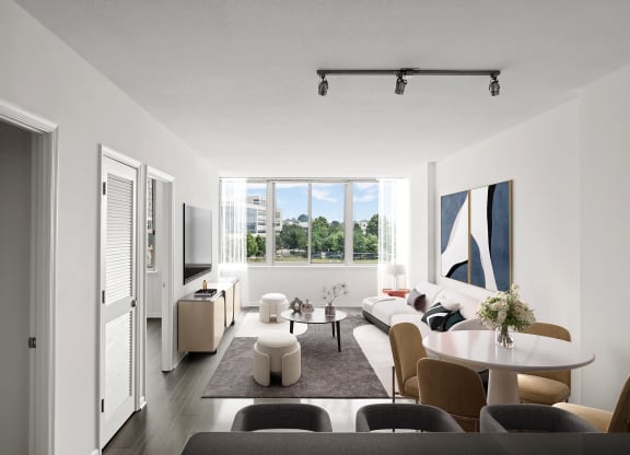 a living room with white walls and a large window