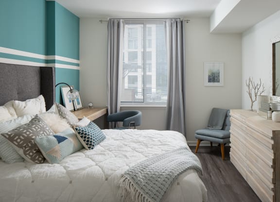 a bedroom with a bed and a dresser and a window