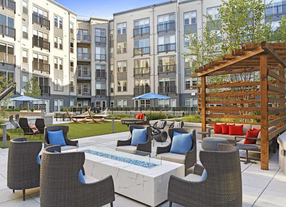 A patio with a table and chairs is surrounded by apartment buildings.