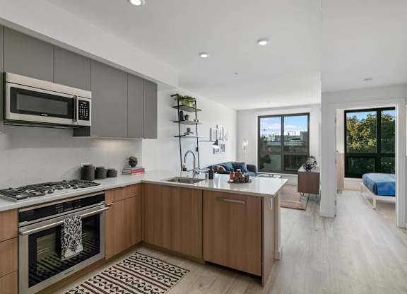 A modern kitchen with wooden cabinets and a stainless steel oven.