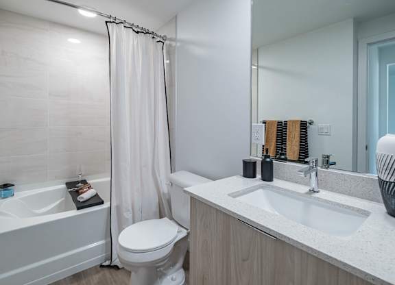 A white bathroom with a toilet, sink, and bathtub.