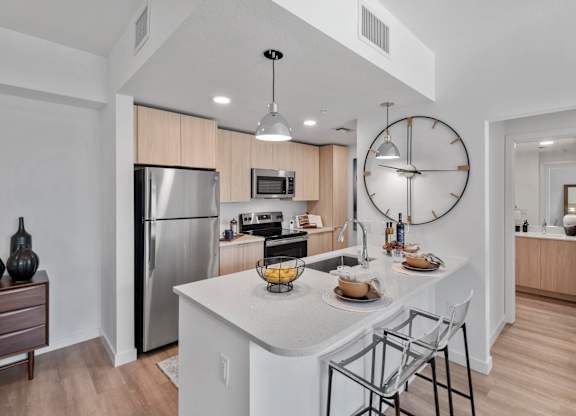 A modern kitchen with a large island and stainless steel appliances.