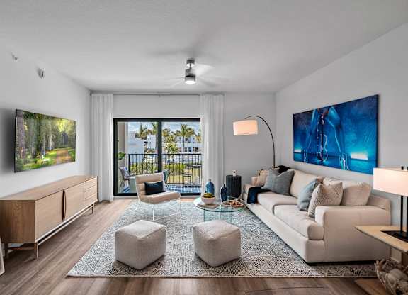 A modern living room with a large window and a painting on the wall.