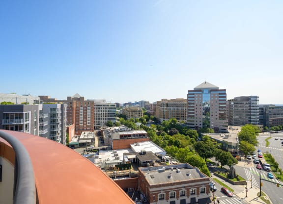 a view of the city from the balcony of a building on a sunny day