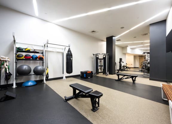 a gym with weights and other equipment on the floor and a tv