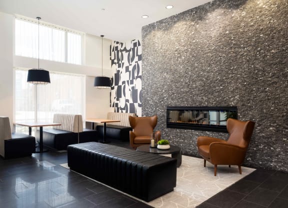 a living room with a fireplace and a black leather couch