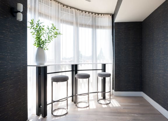 a row of stools in front of a window in a room