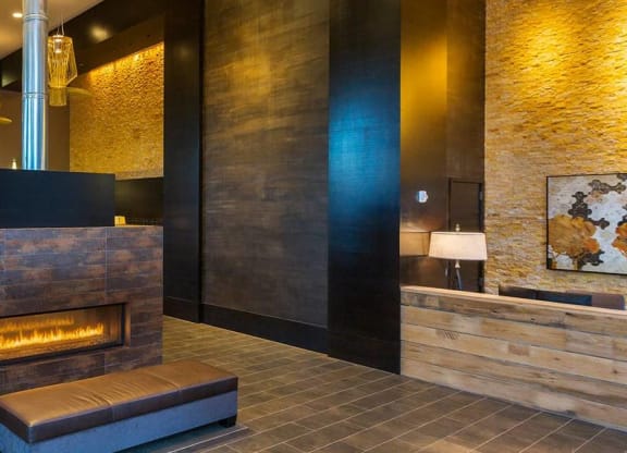 A modern living room with a fireplace and a painting on the wall.