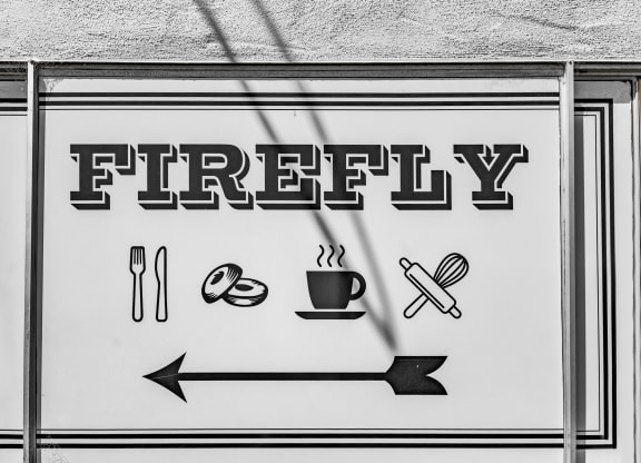 a street sign that reads firey with a arrow pointing to a cup of coffee