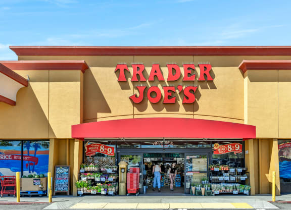 a trader joes store with a red sign on the front of it