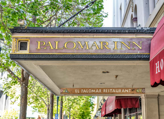 a sign for the palomar inn on the side of a building