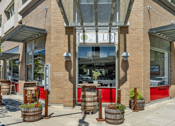 the front of a restaurant with barrels in front of it