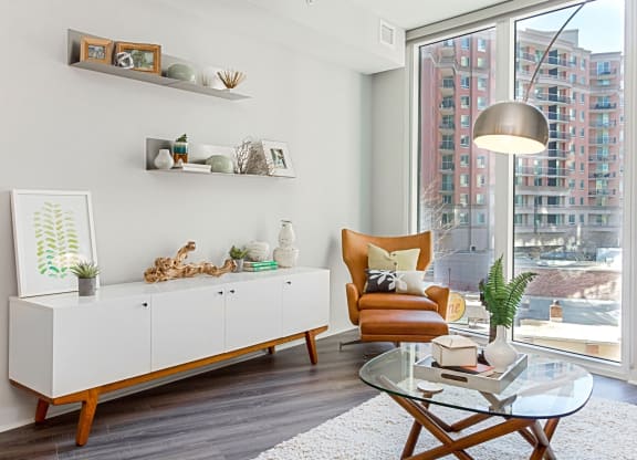 a living room with a large window and a glass coffee table