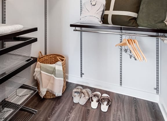 a walk in closet with shelving and a bench with pillows