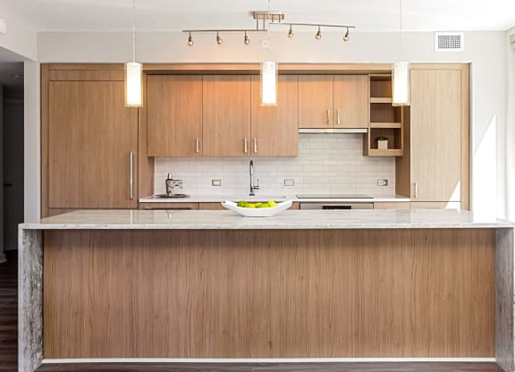 a kitchen with wooden cabinets and a white bowl on the counter