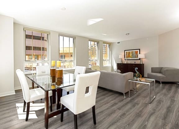 a living and dining room area with a glass table and white chairs
