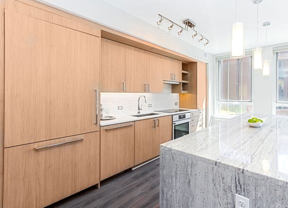 a kitchen with wooden cabinets and a marble counter top