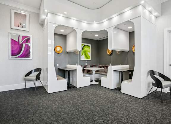 A white reception area with a grey carpet and a white chair.