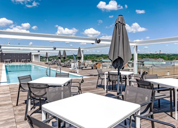 Rooftop deck with dining tables near the pool