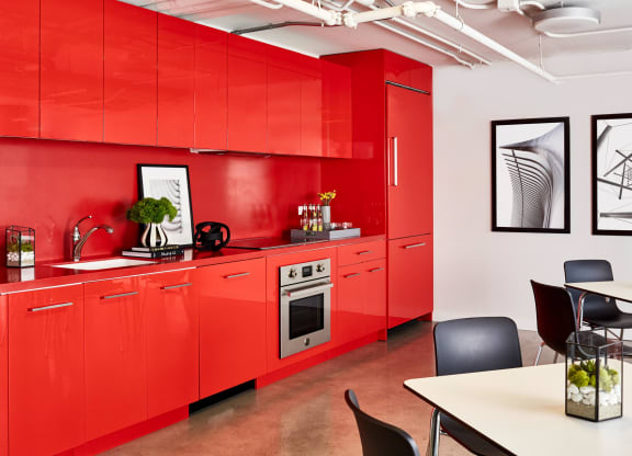 a kitchen with red cabinets and a table and chairs