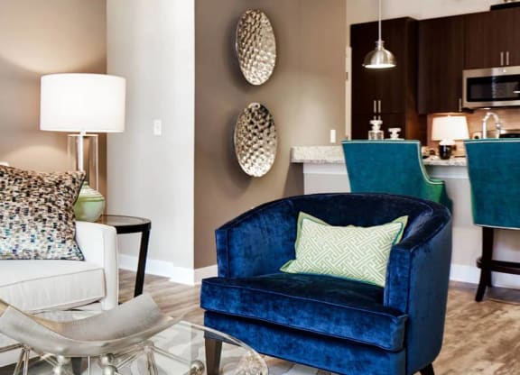 A living room with a white couch and a blue chair.