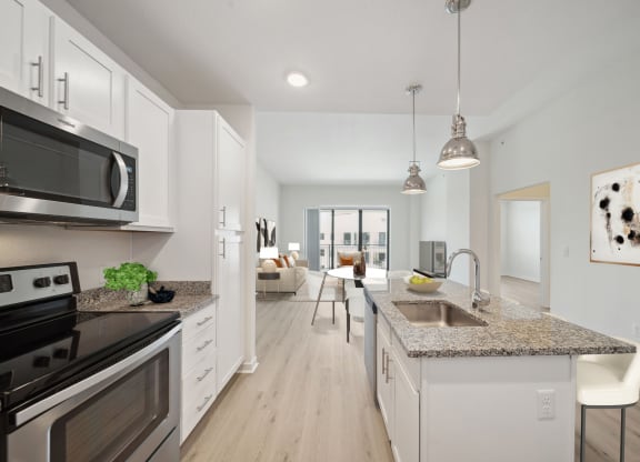an open kitchen and living room with a sink and counter top
