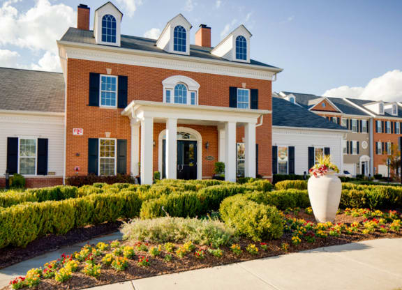 a large brick building with a large vase of flowers in front of it