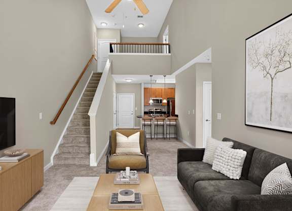 Virtually staged two-story living room at Enclave at Emerson with high ceilings, a staircase to an open loft, lounge seating and a kitchen with breakfast bar seating.