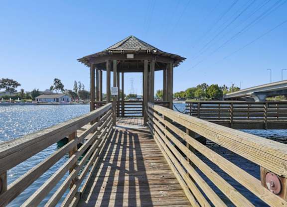 Wooden dock pavilion at Marlin Cove Apartments overlooking the waterfront lagoon.