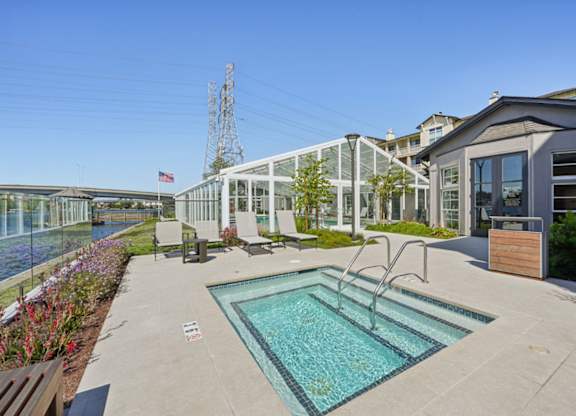 hot tub with waterfront views and outdoor seating