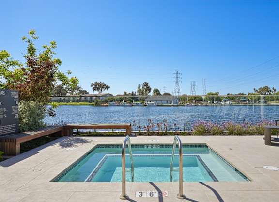 Waterfront spa at Marlin Cove Apartments with scenic lagoon views and outdoor seating.