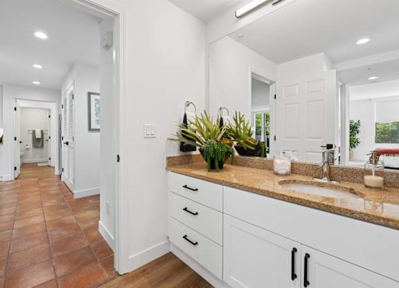 Modern bathroom at Marlin Cove Apartments with updated vanity, wood-style flooring, and bright interiors.