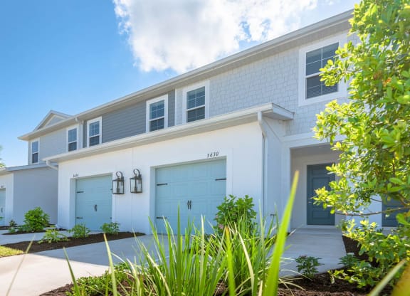 a white house with blue garage doors