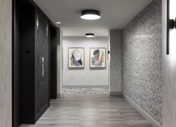 a hallway with two paintings on the wall and a door