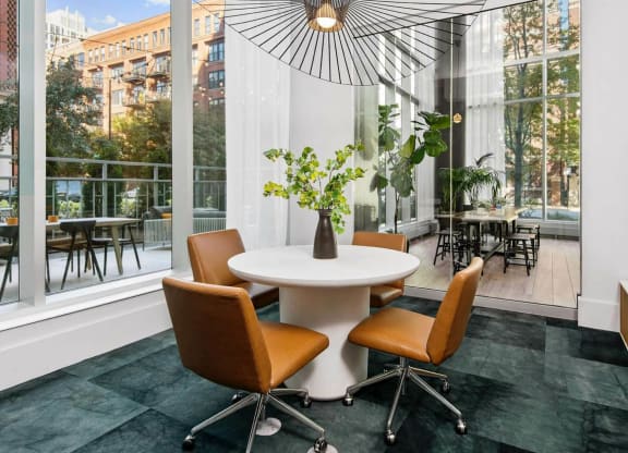 a dining area with a table and four chairs and a large window with a view of a
