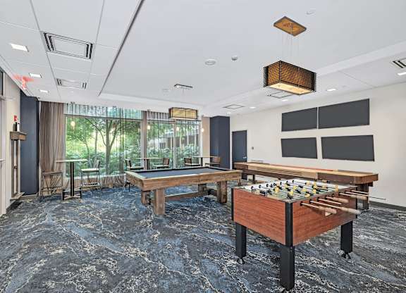 A room with a pool table and a billiard table.
