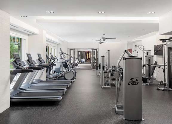 A gym with treadmills, weights, and exercise equipment.
