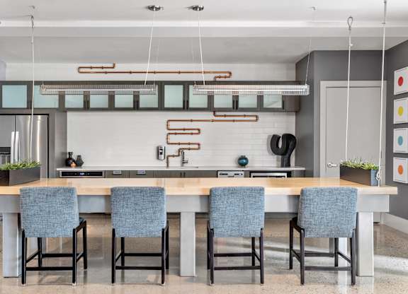 A modern kitchen with a long table and chairs.