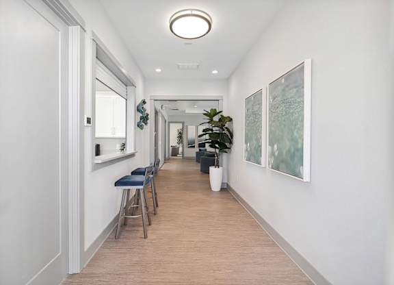 A long hallway with a bench and a plant.