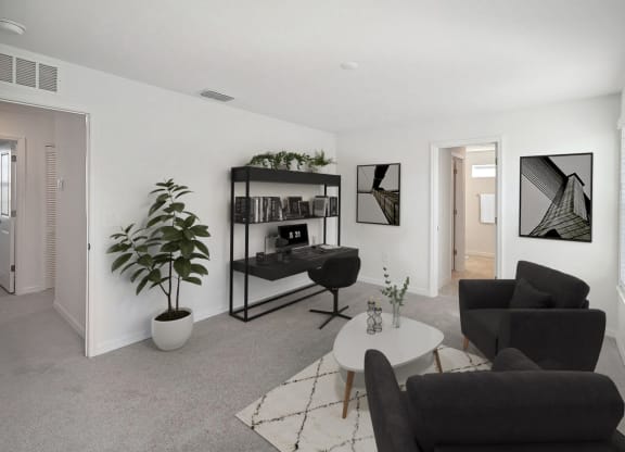 a living room with two black couches and a white coffee table