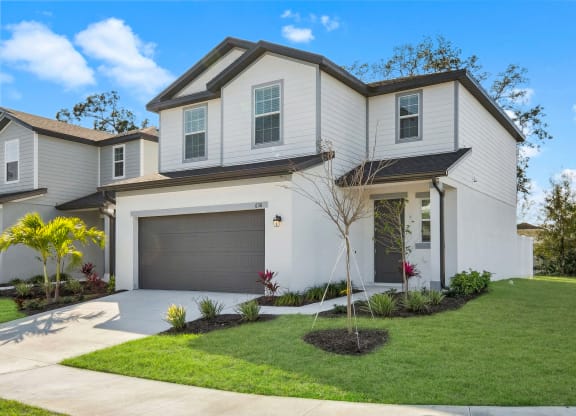 a home with white siding and a gray garage door