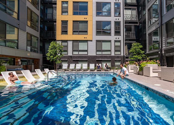 A swimming pool in a courtyard surrounded by buildings.