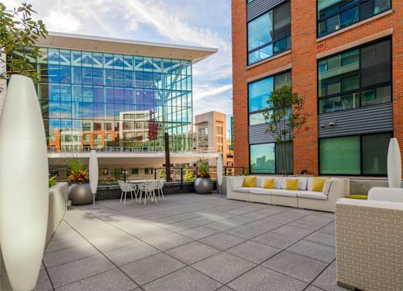 A modern outdoor seating area with white furniture and a large white sculpture.