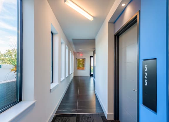 A long hallway with a blue door and a sign that says 525.