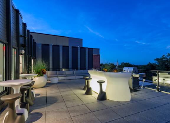 A modern outdoor seating area with a white table and chairs.