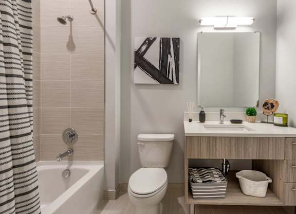 A bathroom with a toilet, sink, and a shower curtain.